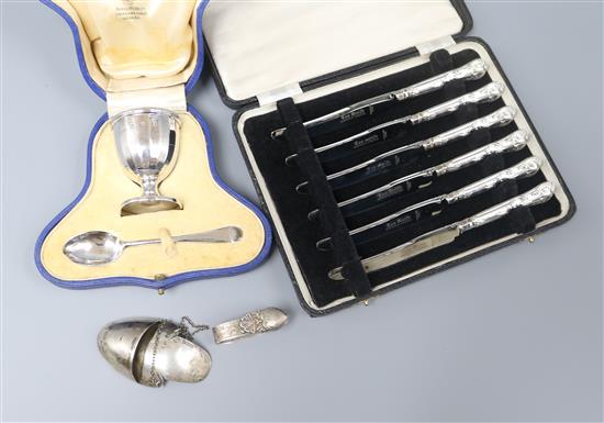 A cased silver christening spoon and egg cup, a cased set of tea knives and two other items.